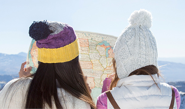 Two Girl Scouts with winter hats reading a paper map