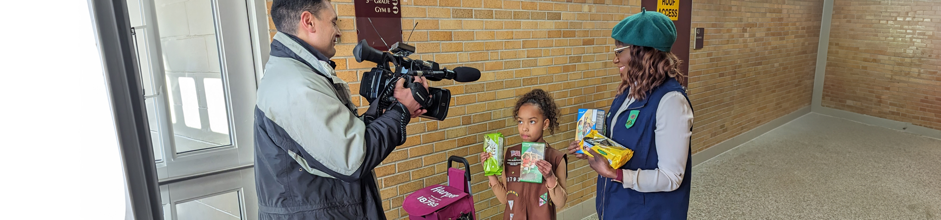  Brownie Girl Scout shares her cookie sale with a news cameraman 