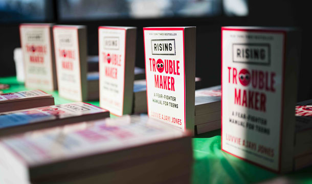 Rising Troublemaker books displayed on a green tablecloth