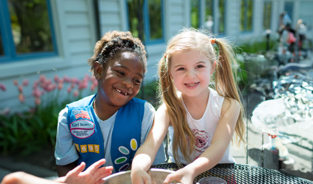 Two Daisy Girl Scouts smiling outside