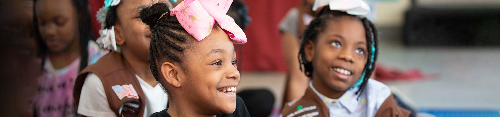  Two Girl Scouts with hair bows smiling together 