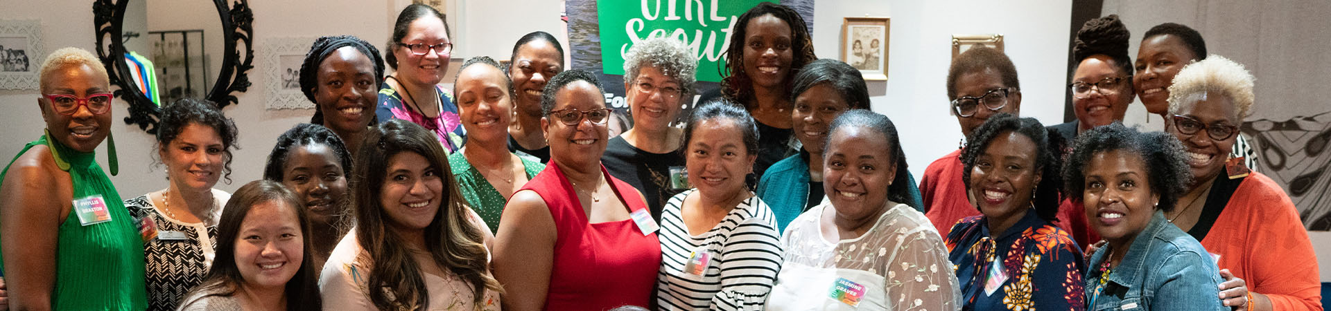  group of young girl scout alums smiling and talking to one another 