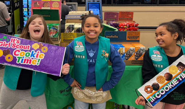 Girl Scouts in front of their indoor cookie booth