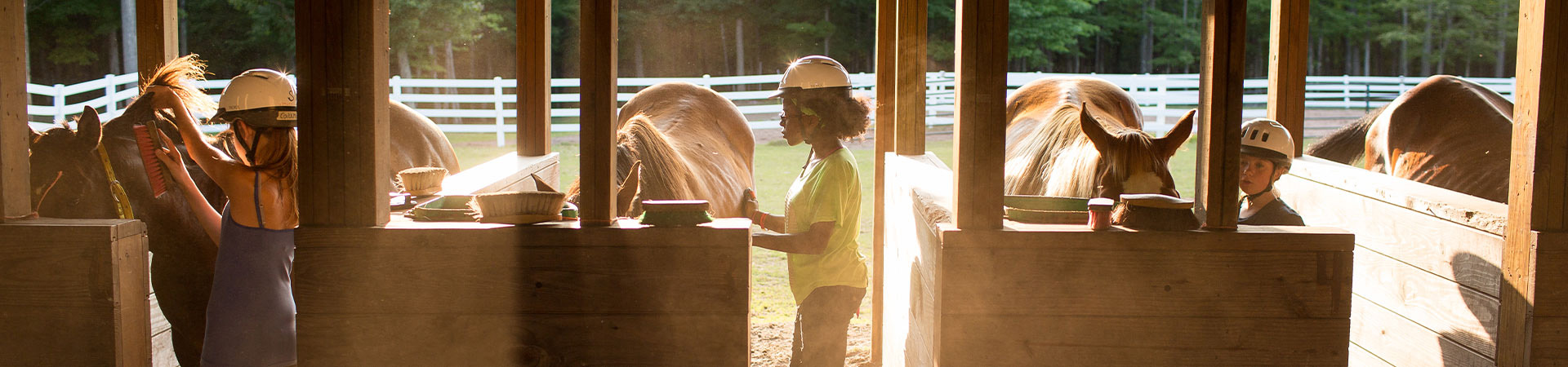  girls prepare horses for a morning ride at camp 