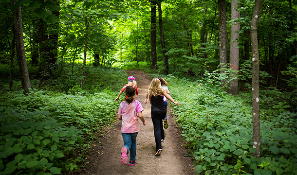 Girls running down a camp trail