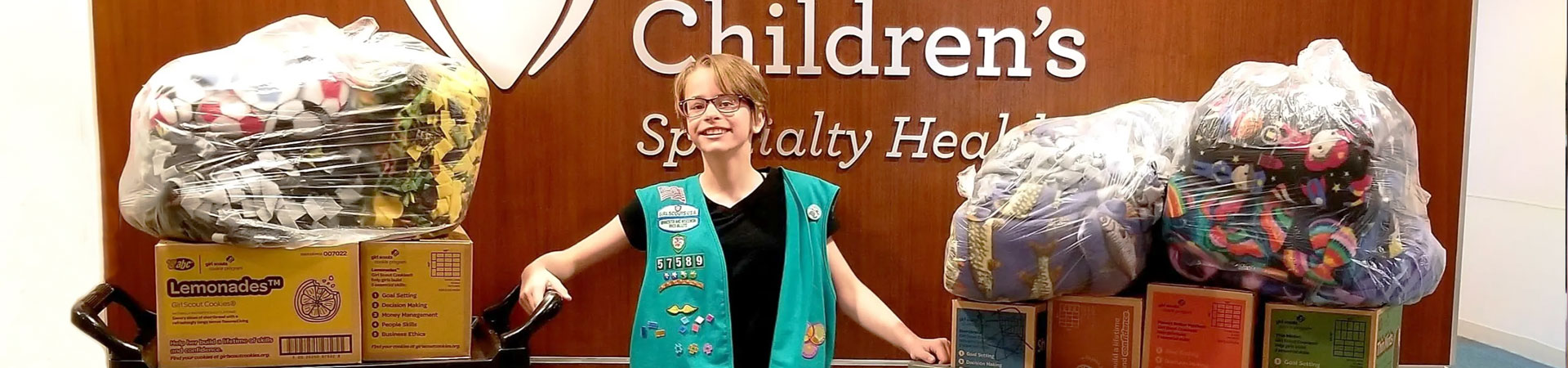  A Junior Girl Scout with carts of cookie donations at the Children's Hospital 