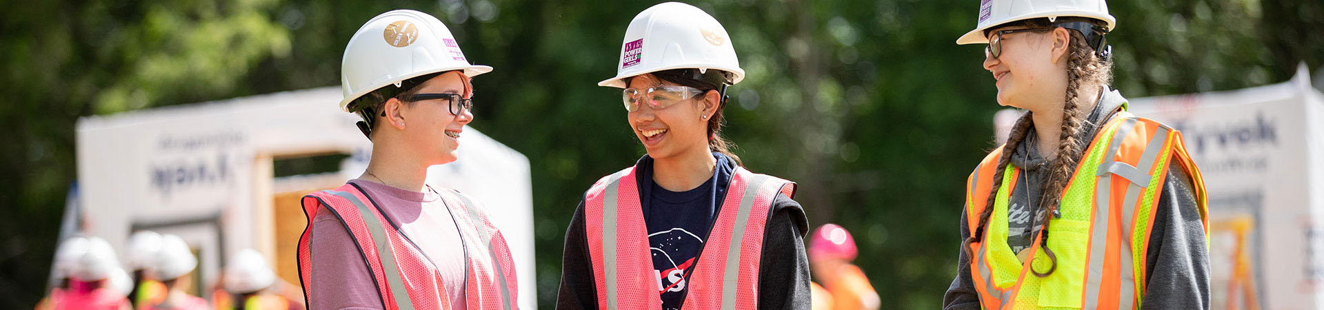  three Girl Scouts in hard hats and safety vests 