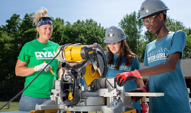 Two volunteers supporting a girl on a bike