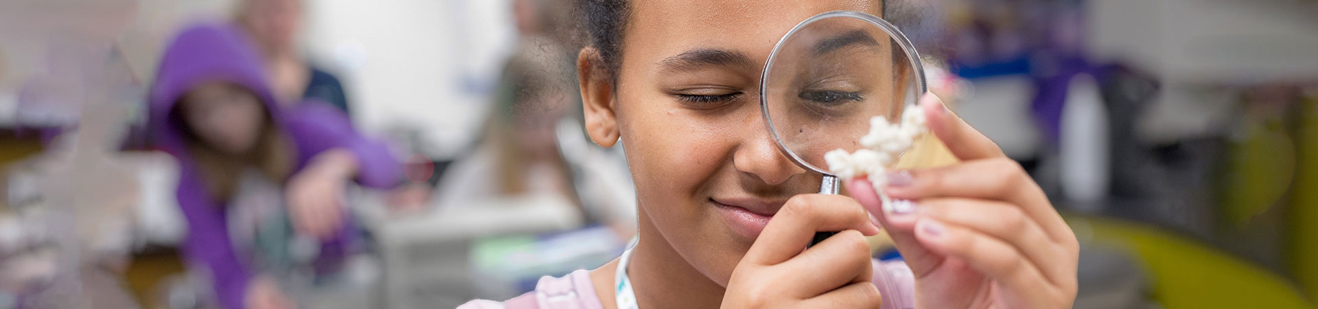  girl scout using a magnifying glass at an event  